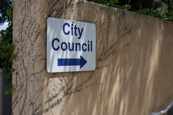 A wayfinding sign with an arrow points visitors toward the City Council chambers at Stillwater City Hall.