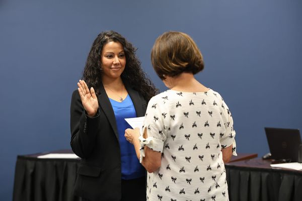 Kiah Butcher raises her right hand as Board President Gay Washington administers the oath of office during her swearing-in to the Stillwater Board of Education Tuesday, July 14, 2026.
