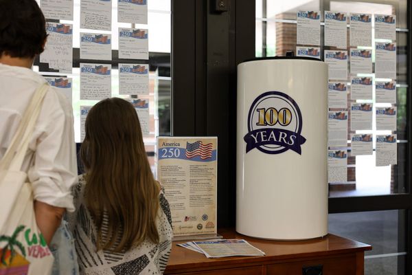 Ariel Ross and her daughter Jane read handwritten book nomination narratives taped to a window beside the Stillwater Public Library's time capsule, Tuesday, July 21, 2026.