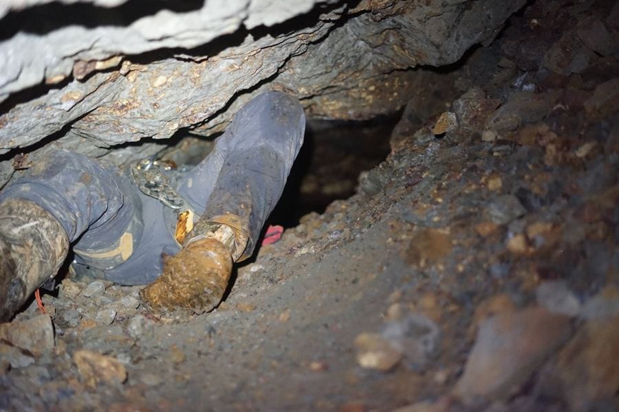 Frank Schlichting on a break in a mine drift, his camera and bottles on a cable-spool table.