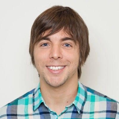 Headshot of Eugenio R. Teal-based plaid shirt, brown hair, blue eyes.