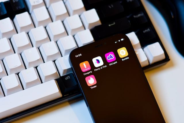 Mobile phone screen with computer keyboard in the background.