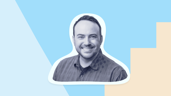 A black and white headshot of Andrew Vernon on a blue background with beige and light blue shapes.