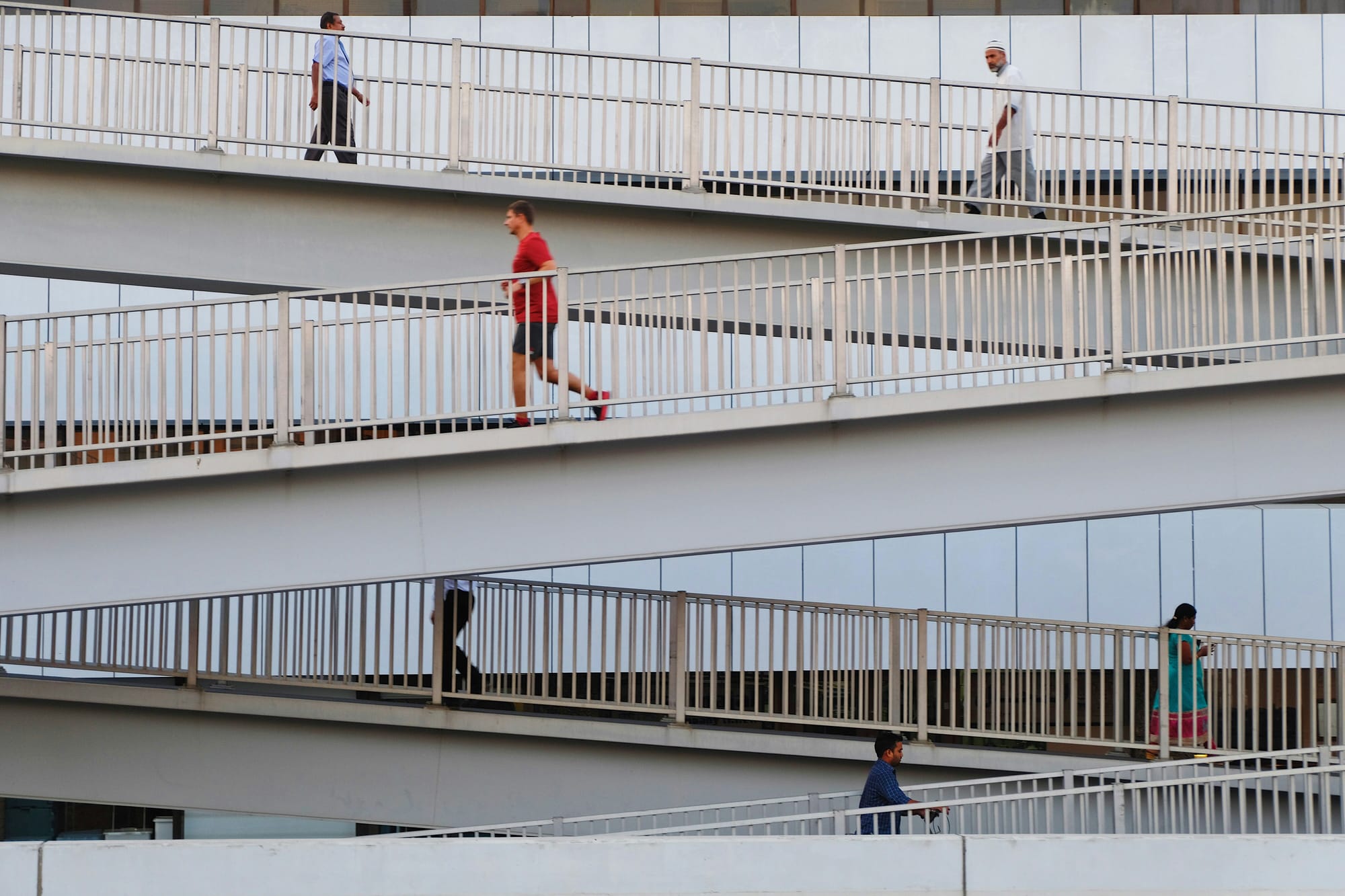 Multiple people walking or running up and down outdoor ramps.