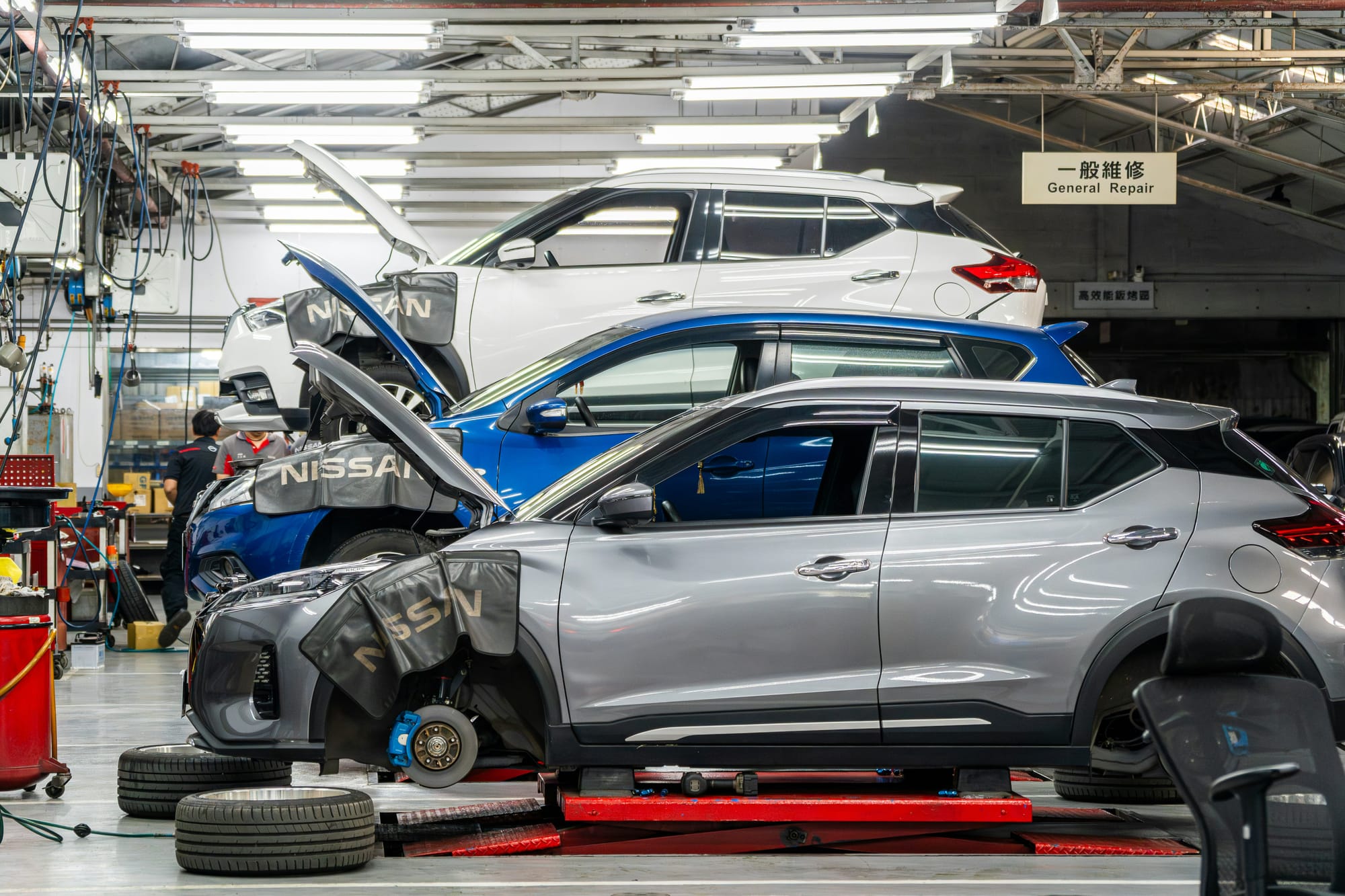 Cars being repaired in a China workshop. Photo by Winston Chen on Unsplash