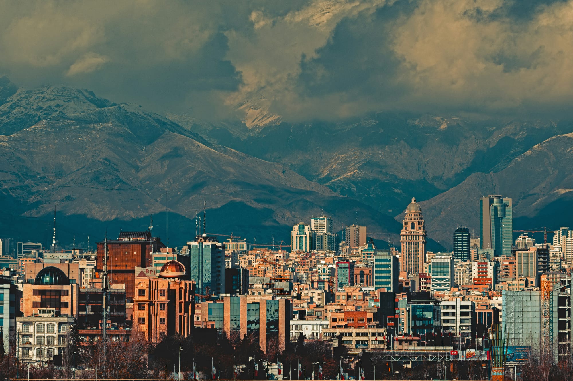 Photo of Tehran with mountains and clouds in the background, afternoon light