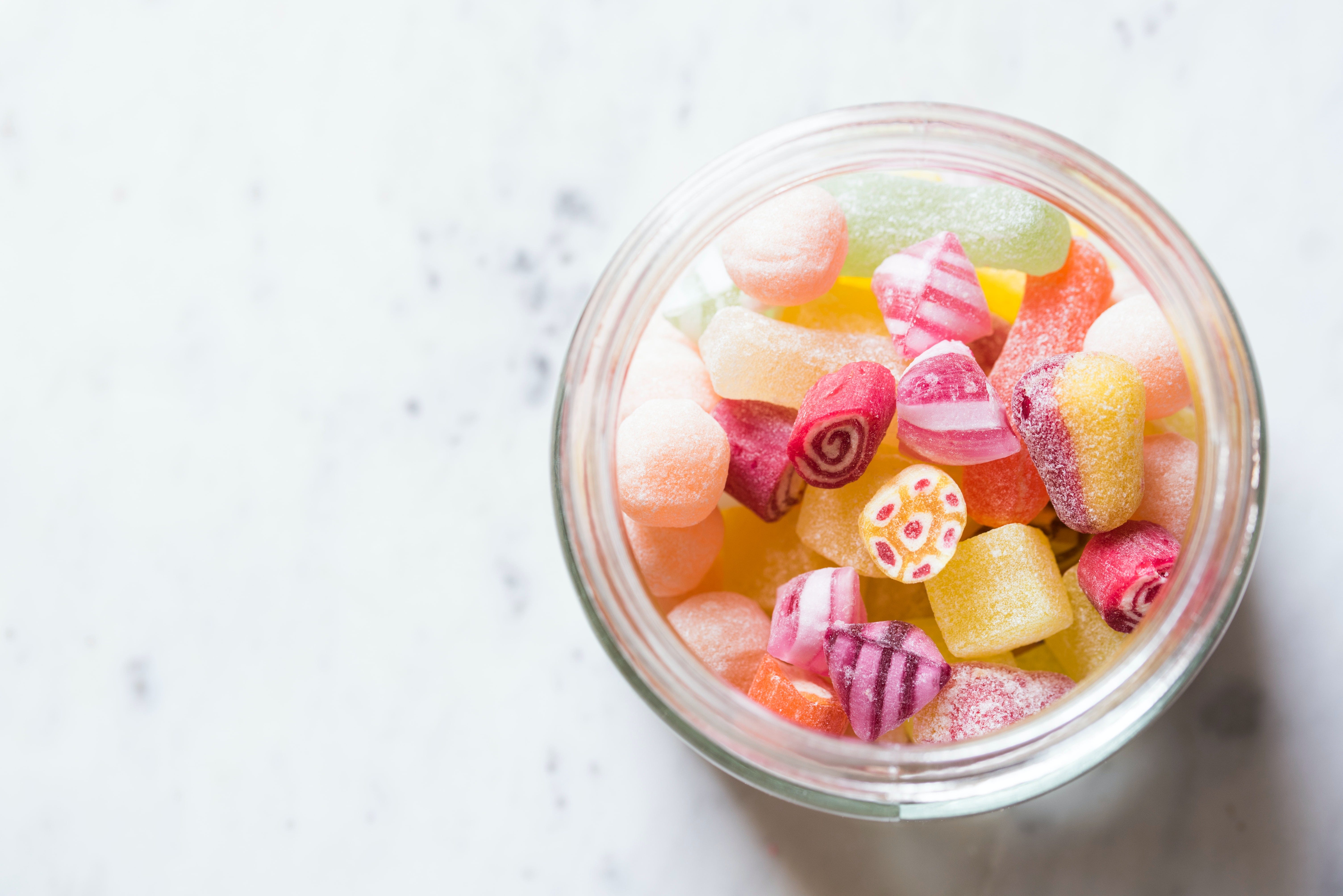 A glass jar containing a variety of sugar coated sweets