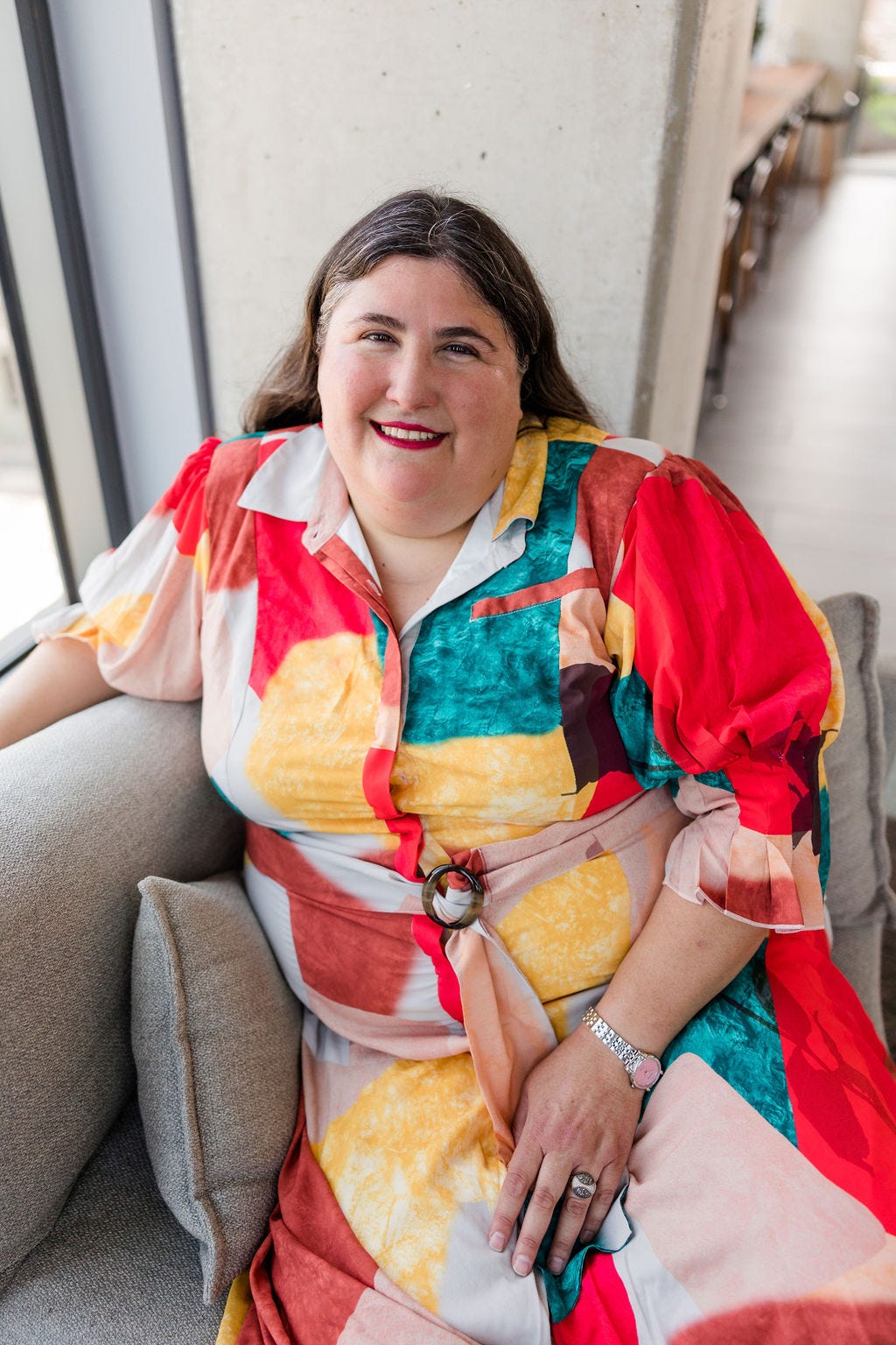Headshot of Rachel Millner sitting on a sofa