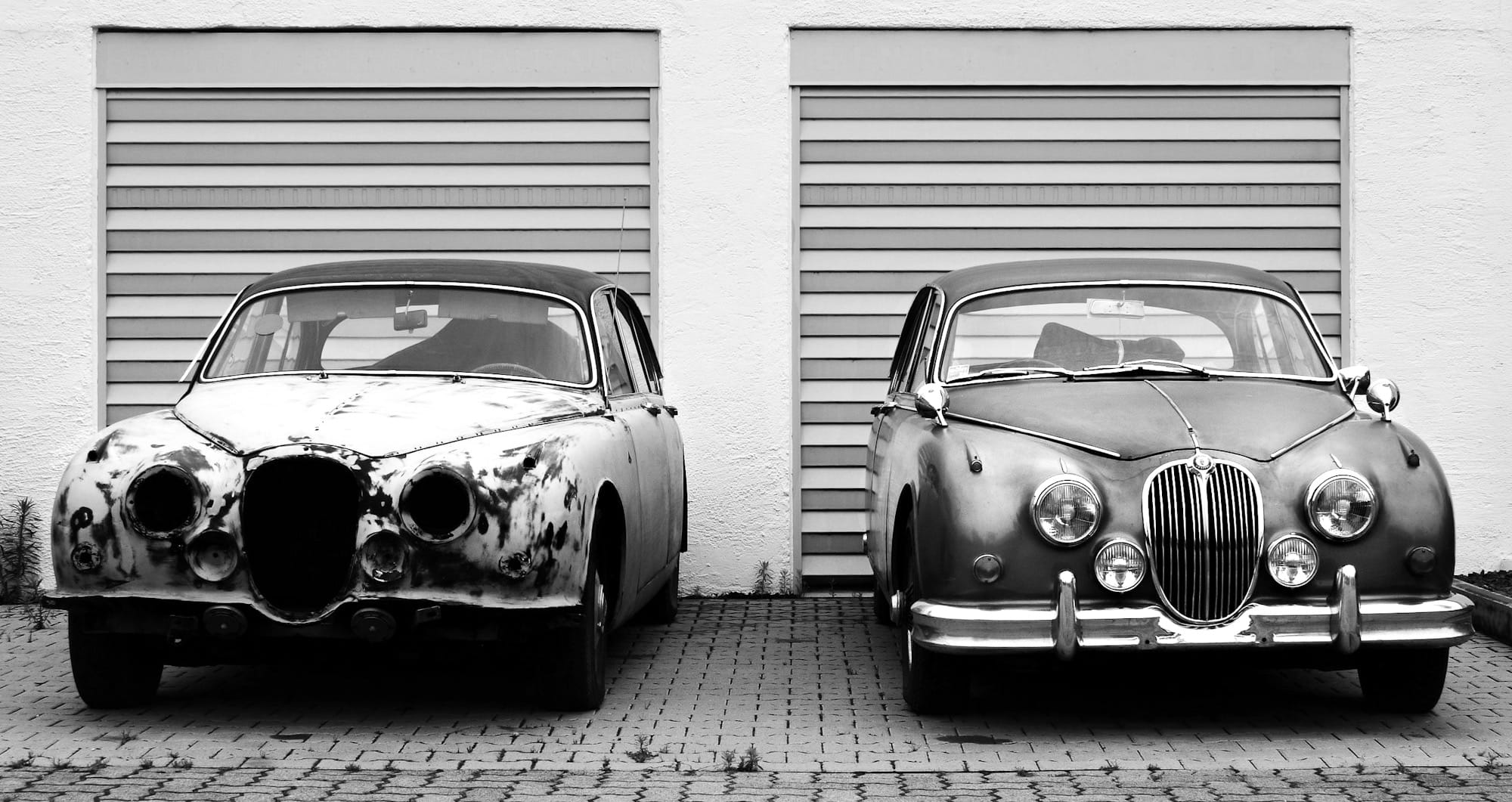 two cars in front of shutter doors
