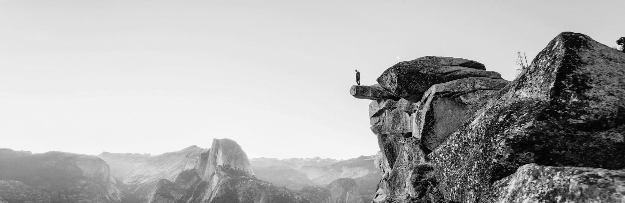 person standing on gray concrete cliff