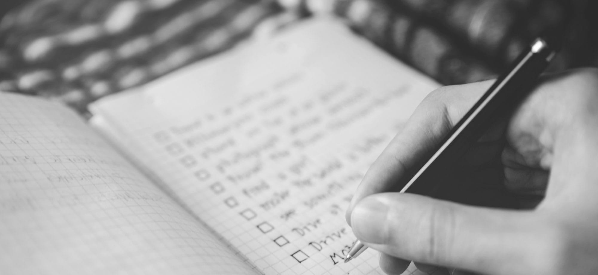 person writing bucket list on book