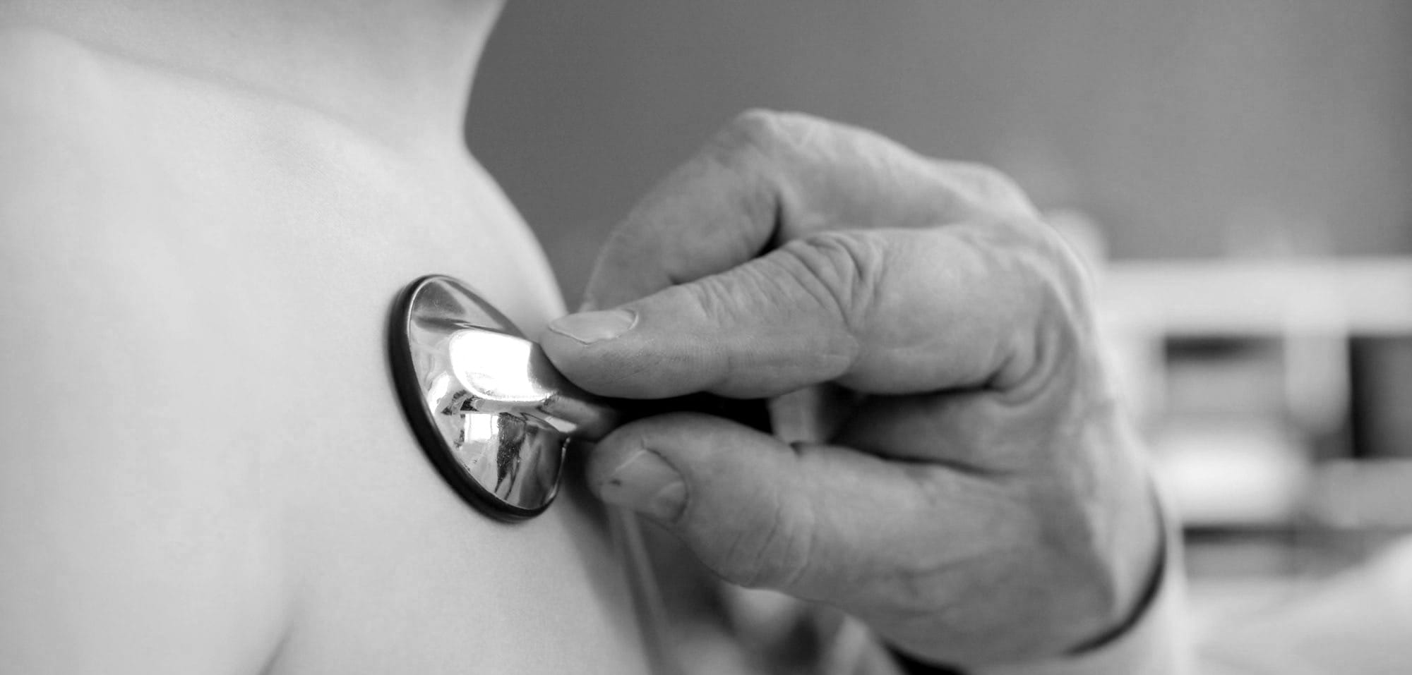 Doctor using stethoscope to examine patient's chest