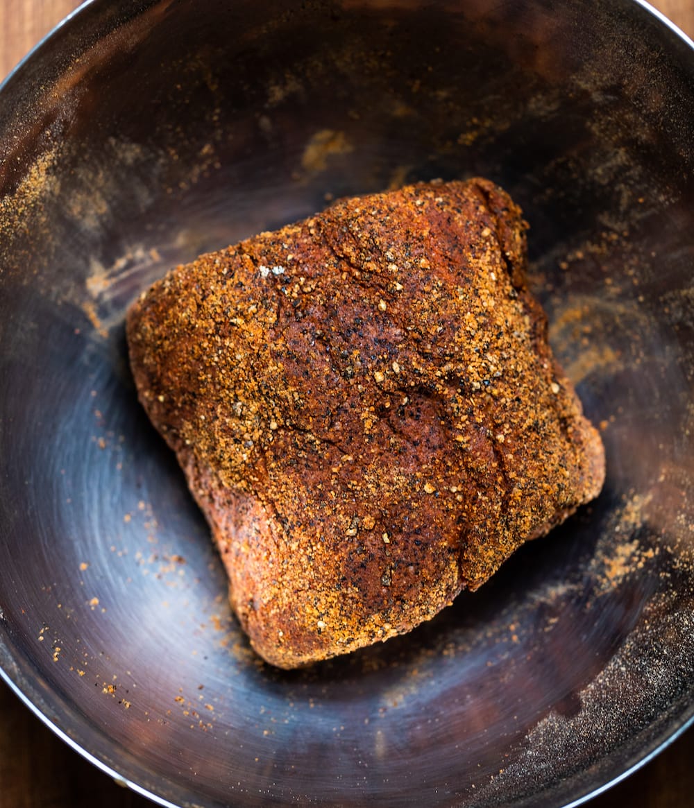 Overhead shot of seasoned slow cooker Texas pulled pork in a stainless bowl