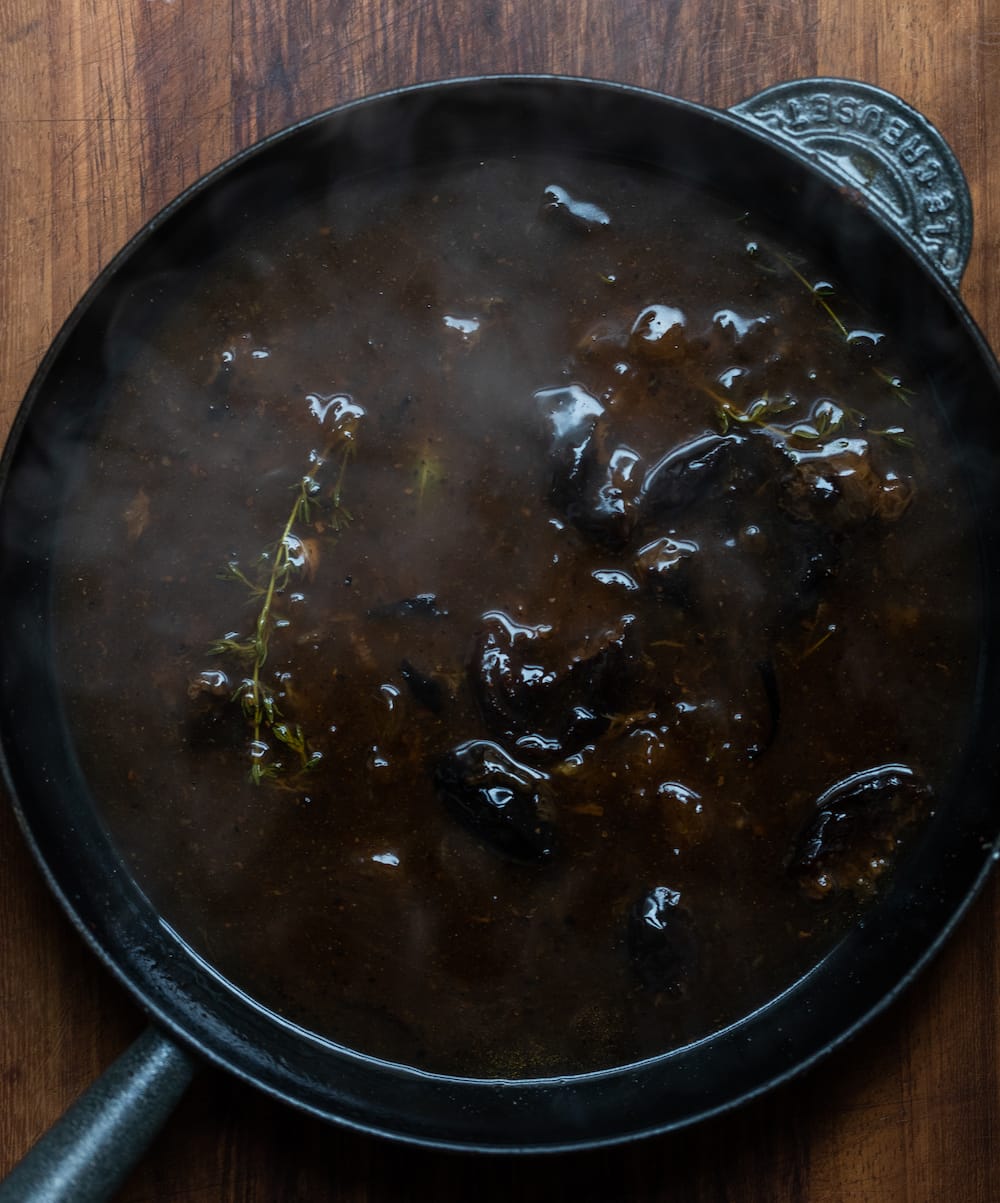 Overhead shot of Texas pulled pork sauce  from the slow cooker in a cast iron to reduce