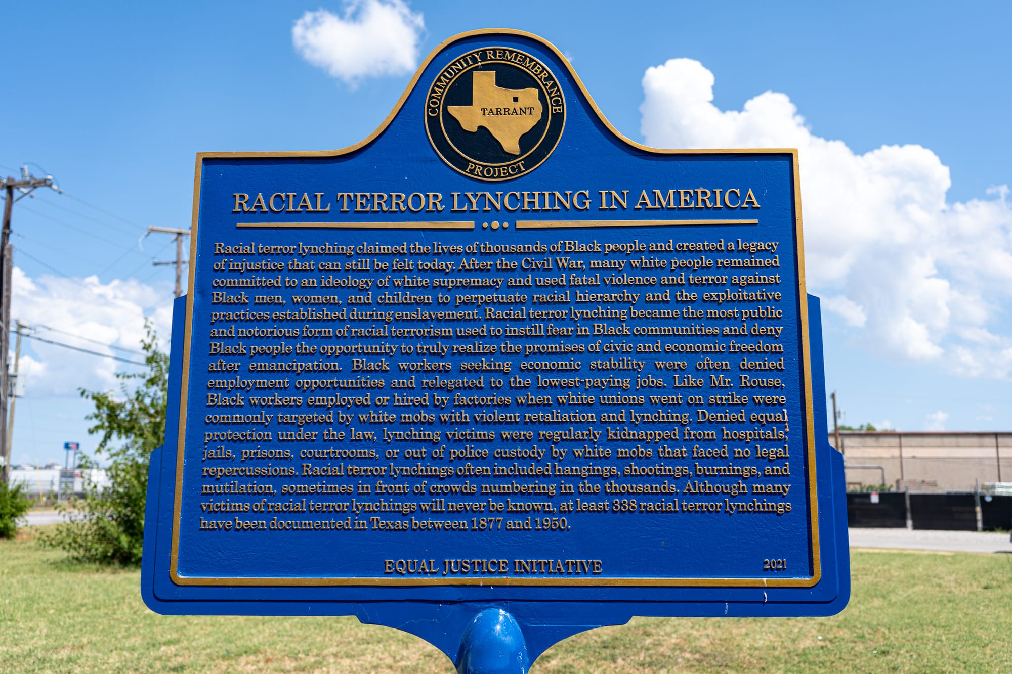 A blue historical marker with the title "Racial Terror Lynching in America"