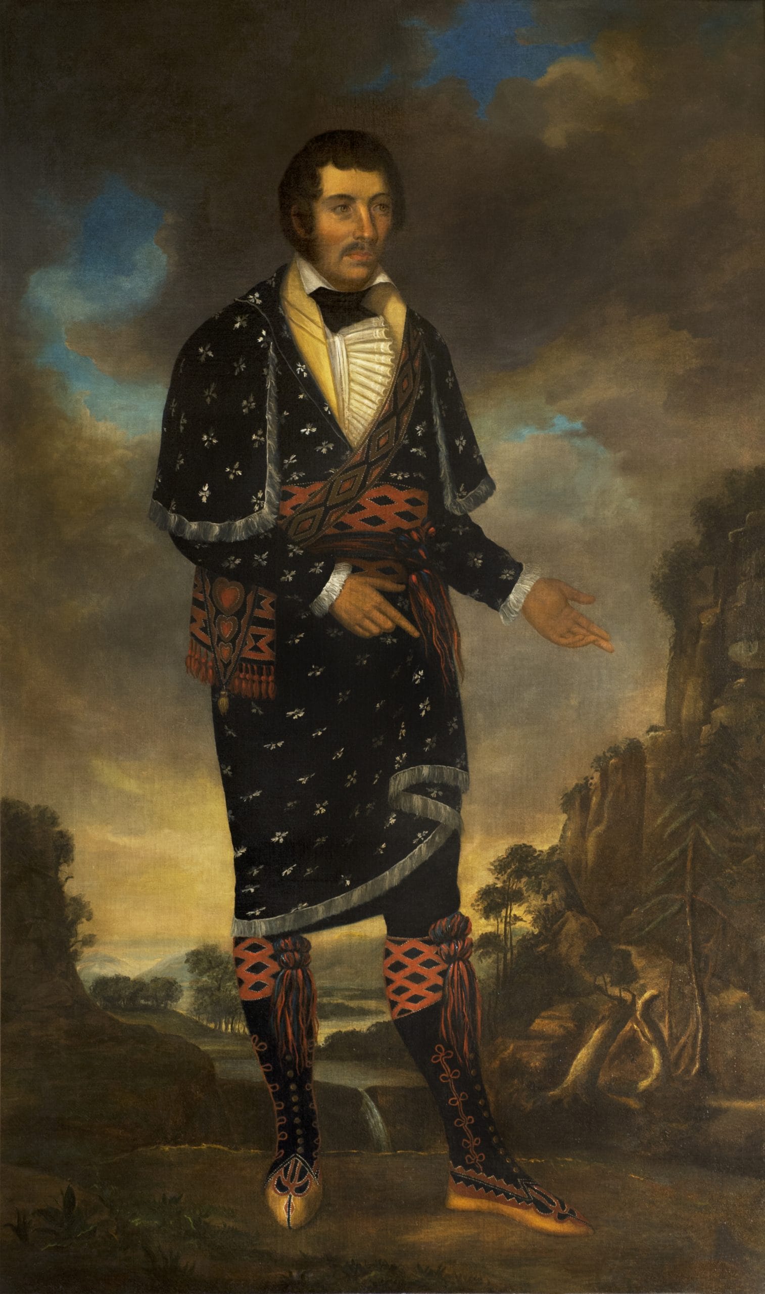 A European-style full body portrait painting of a man in "a fancy, ruffled white shirt, elaborate match coat, woven sash, and moccasins."