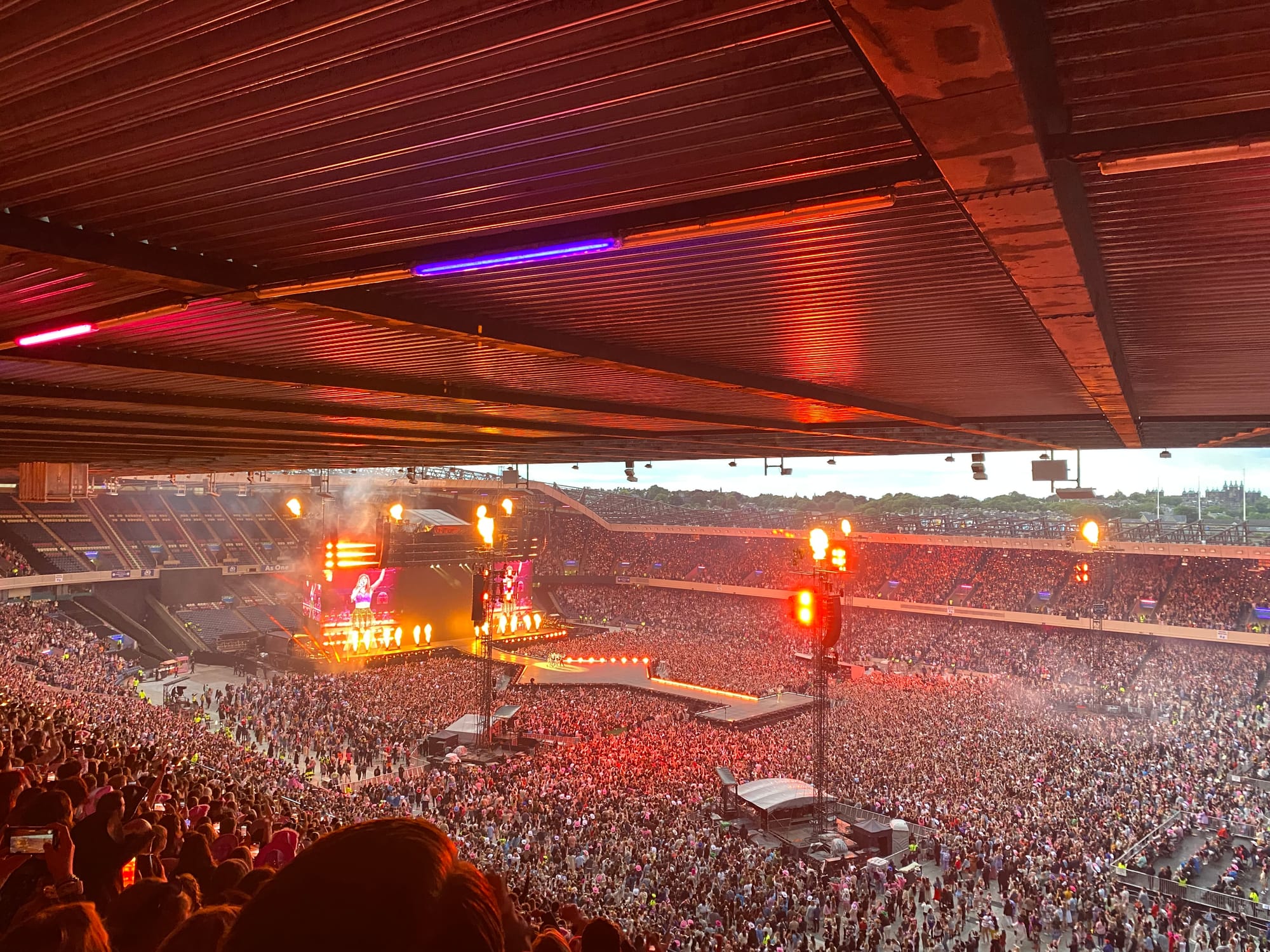 A view of a large stadium crowd, stage and pyrotechnics during a Taylor Swift concert, June 2024
