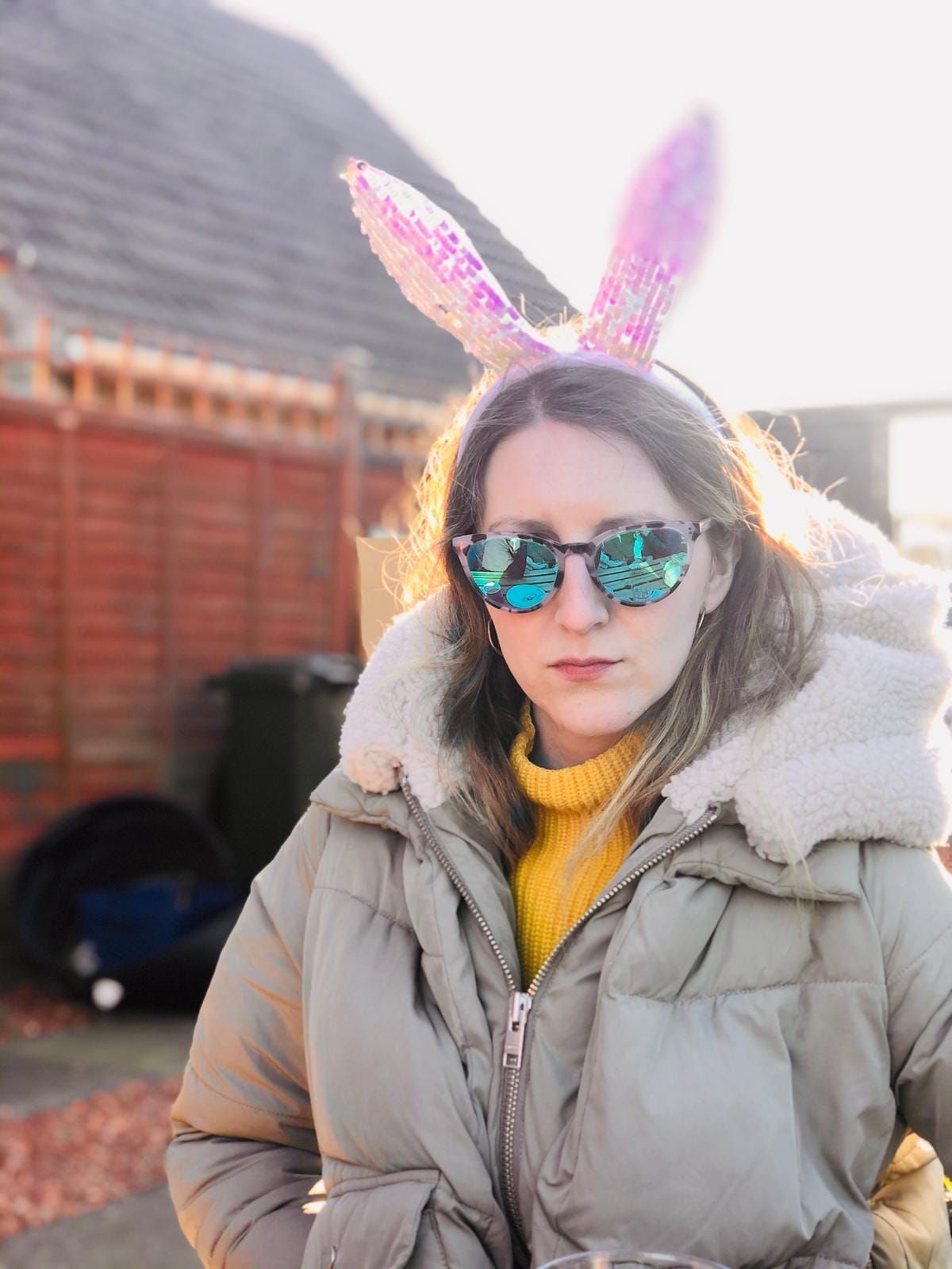 a woman wearing bunny ears and sunglasses.