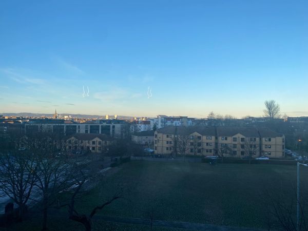A view of the sky, a park and flats.
