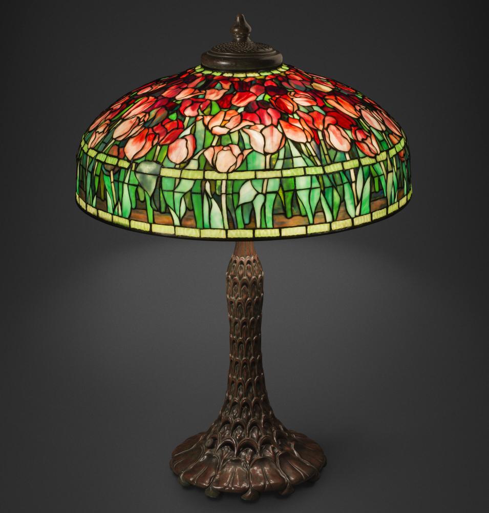An ornate stained glass table lamp features a shade covered in blooming tulips.