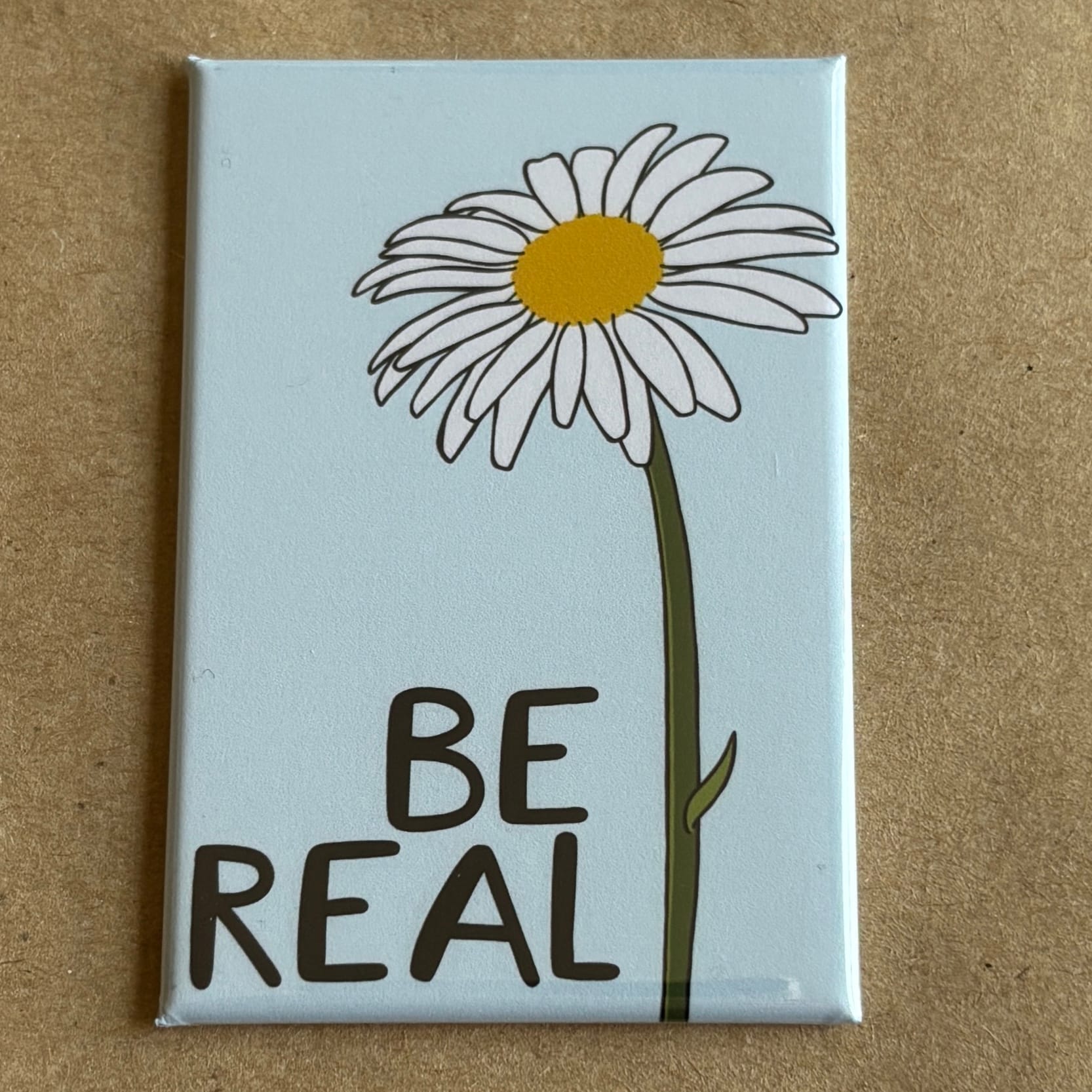original art by AnneArchy of a daisy with hand lettering of the words Be Real.