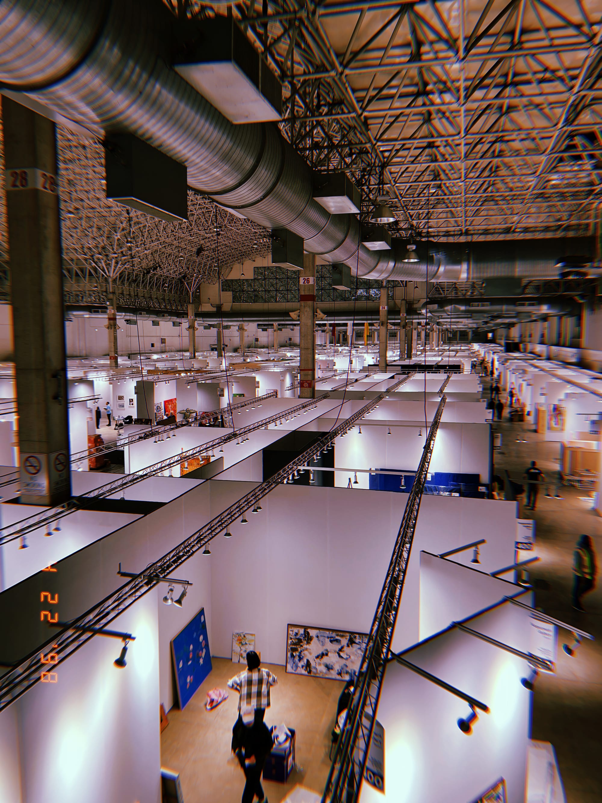 A photo looking down on a cluster of white booths with art inside