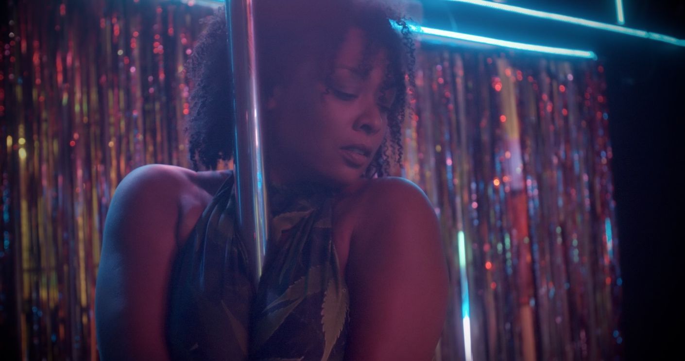 An-image-of-NatsHoney-in-a-green-halter-top-pole-dancing