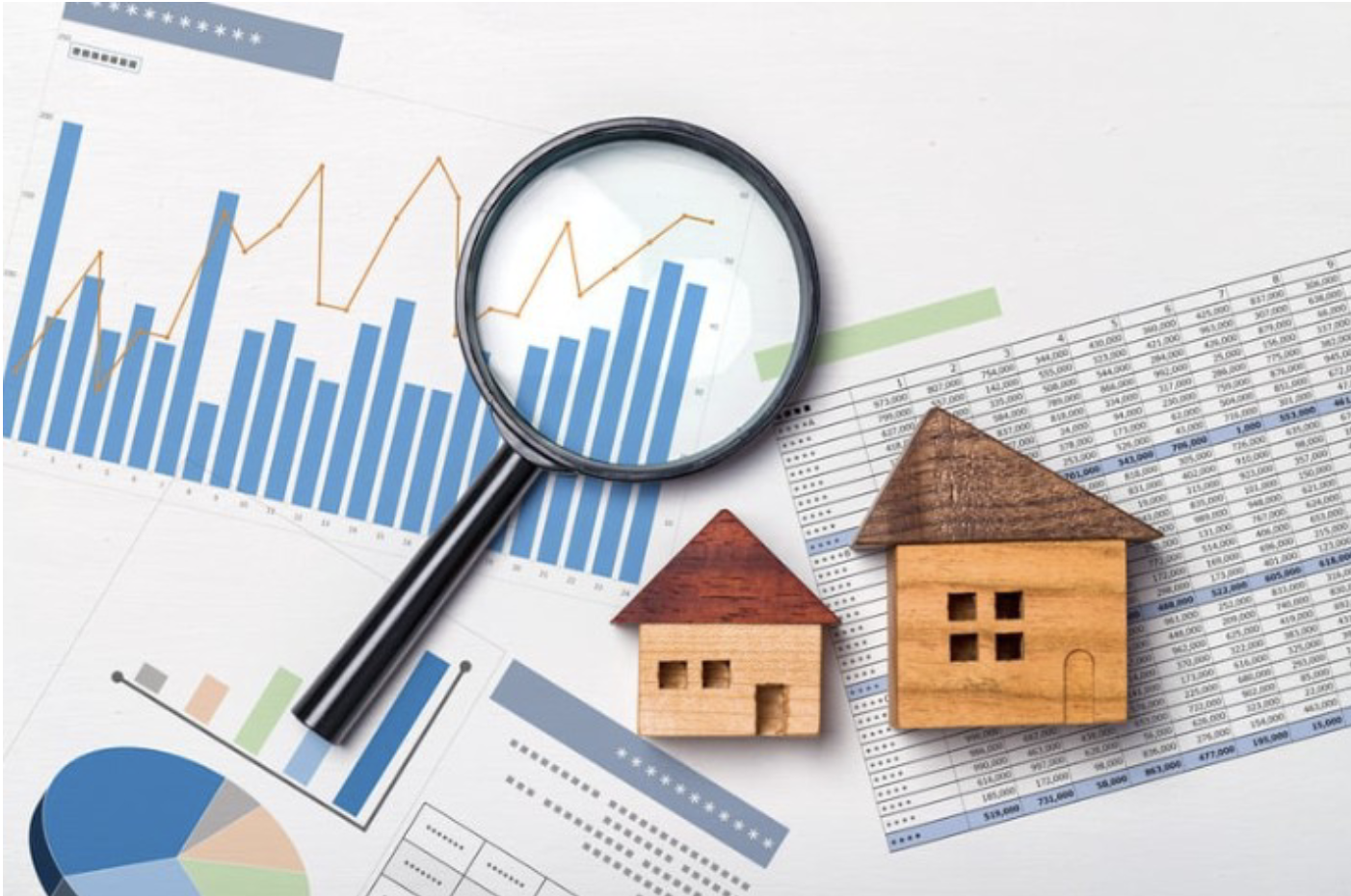 Magnifying glass over housing market data charts with small and large house models.