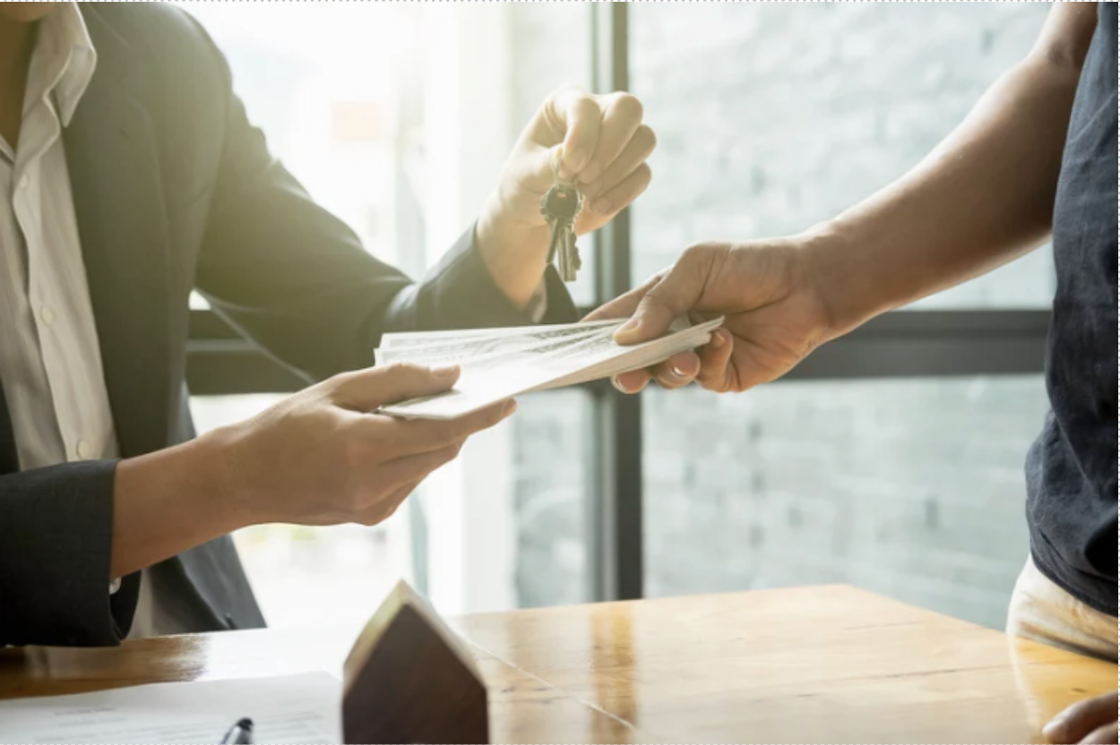 Real estate agent handing over keys and documents during luxury property closing. 