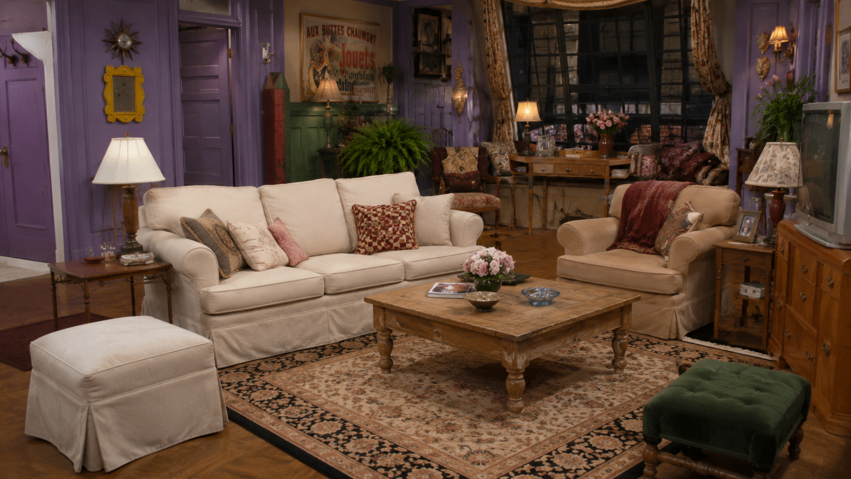 Eclectic purple-toned New York apartment living room with exposed brick and an open kitchen