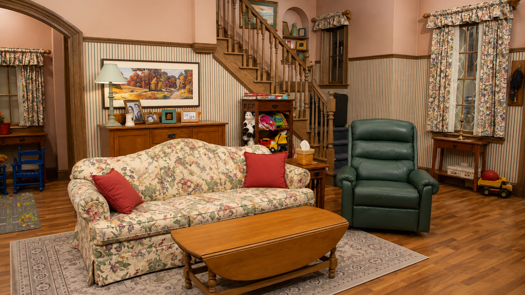 Ordinary late-1990s Long Island living room with a floral sofa, front door and staircase