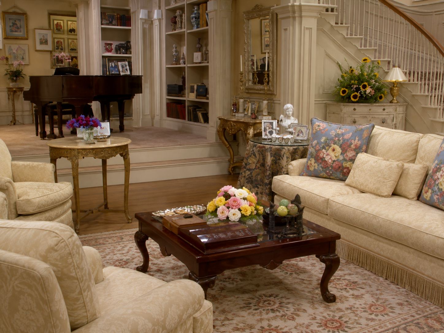Ornate Manhattan townhouse living room with a sweeping staircase and chandelier