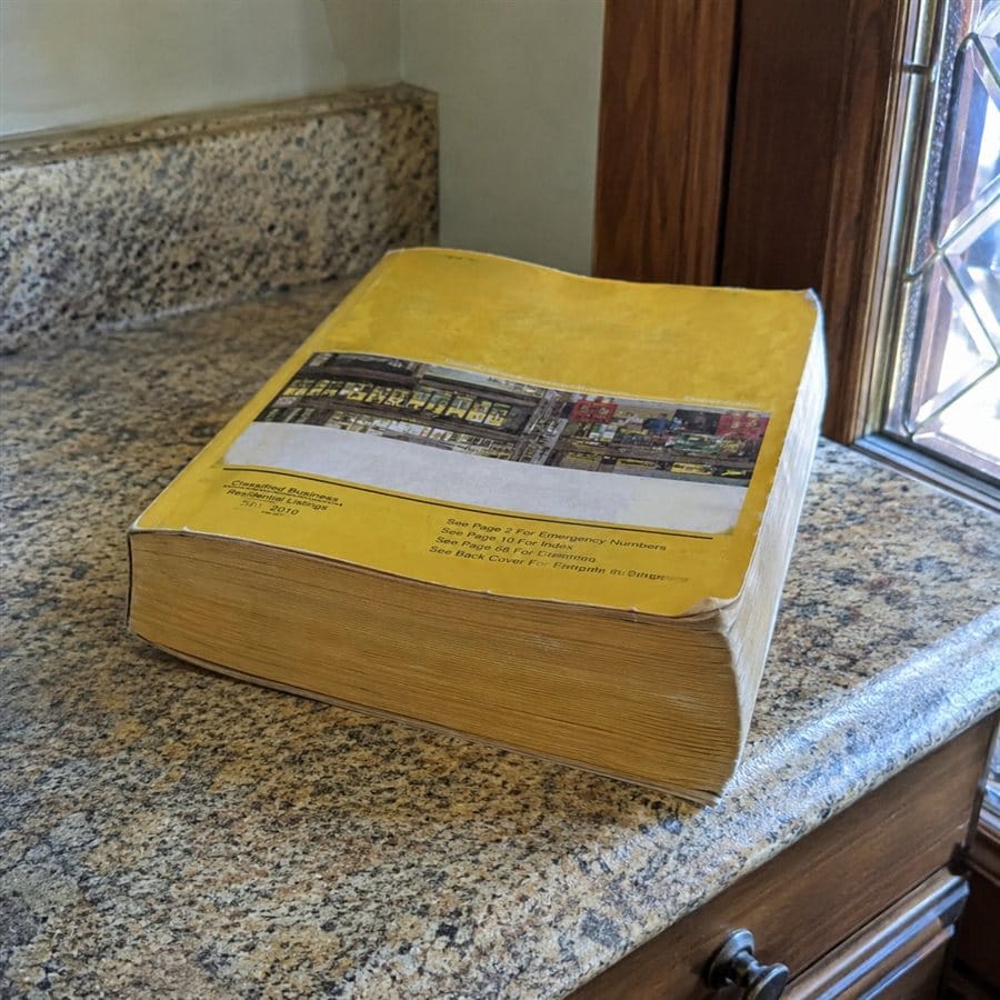 A thick yellow-and-black telephone directory