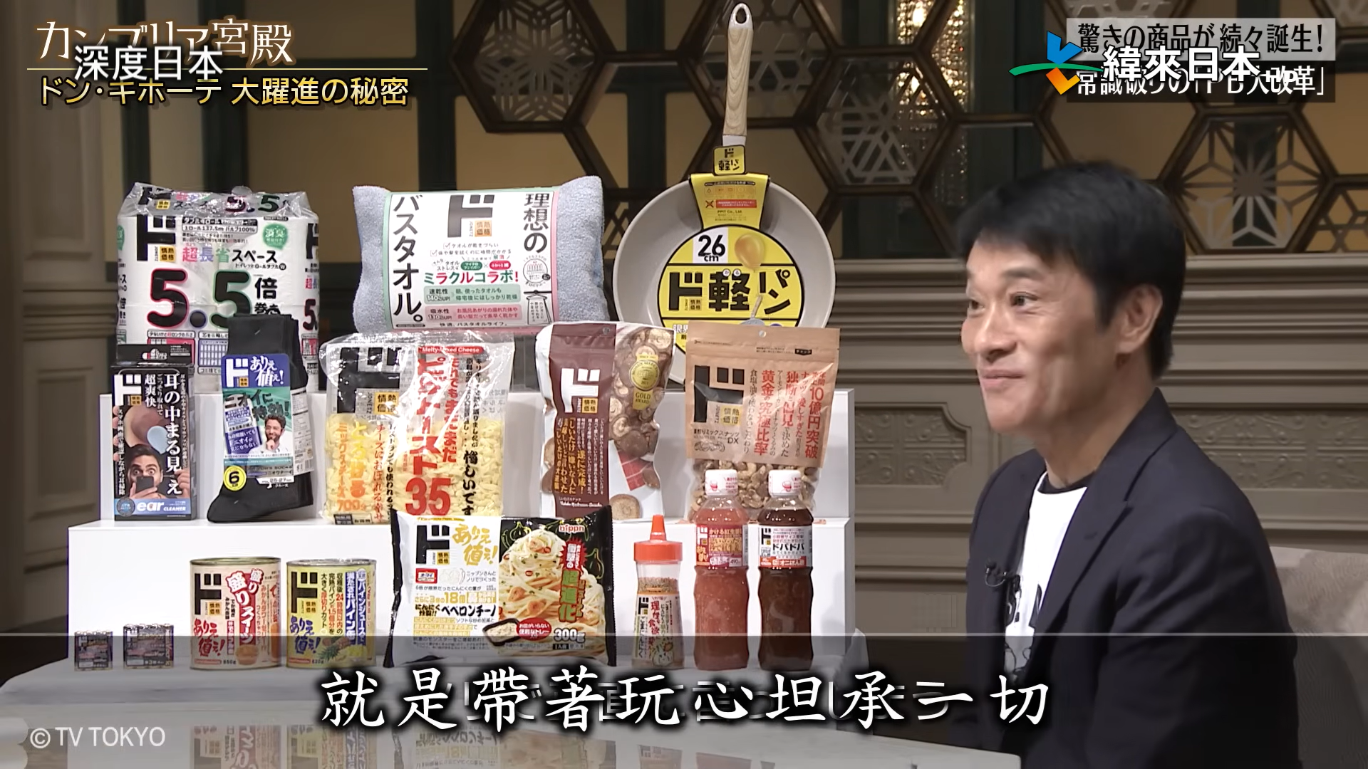 電視節目展示唐吉訶德自有品牌「情熱價格」的食品與日用品，包裝以醒目的文字說明商品特色。