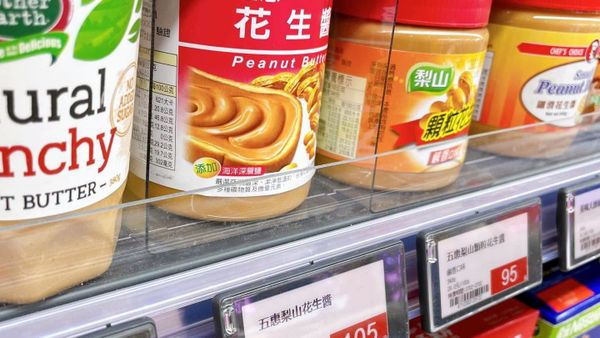 超市貨架上的花生醬商品與電子標籤，電子螢幕顯示商品售價