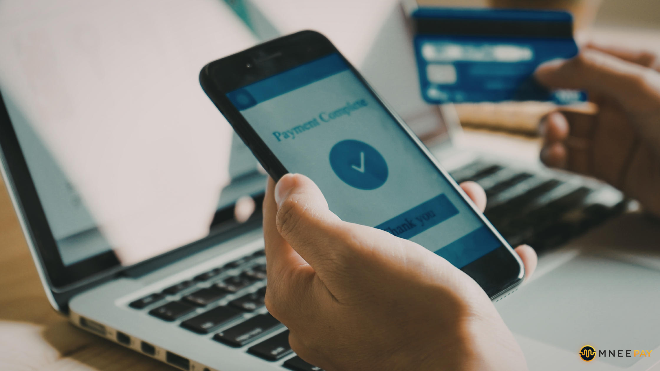 Customer holding credit card and phone while shopping online, illustrating omnichannel payments and payment reconciliation. 