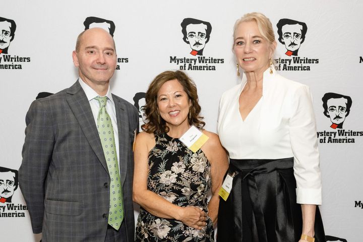 Three people in front of Mystery Writers of America background. 