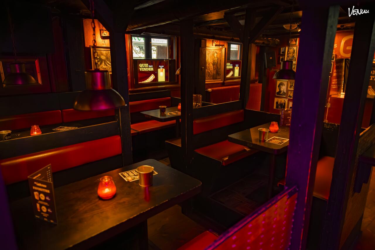 Klassisk bodega-stemning med billige øl, høj energi og festlig julefrokost-atmosfære.