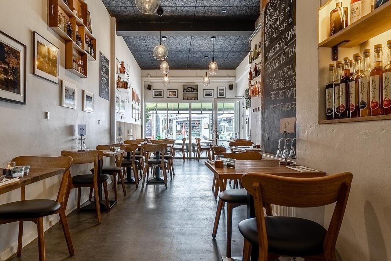 Et hyggeligt festlokale med rustik caféstemning, træmøbler og varme farver hos Kong Volmer i Svendborg.