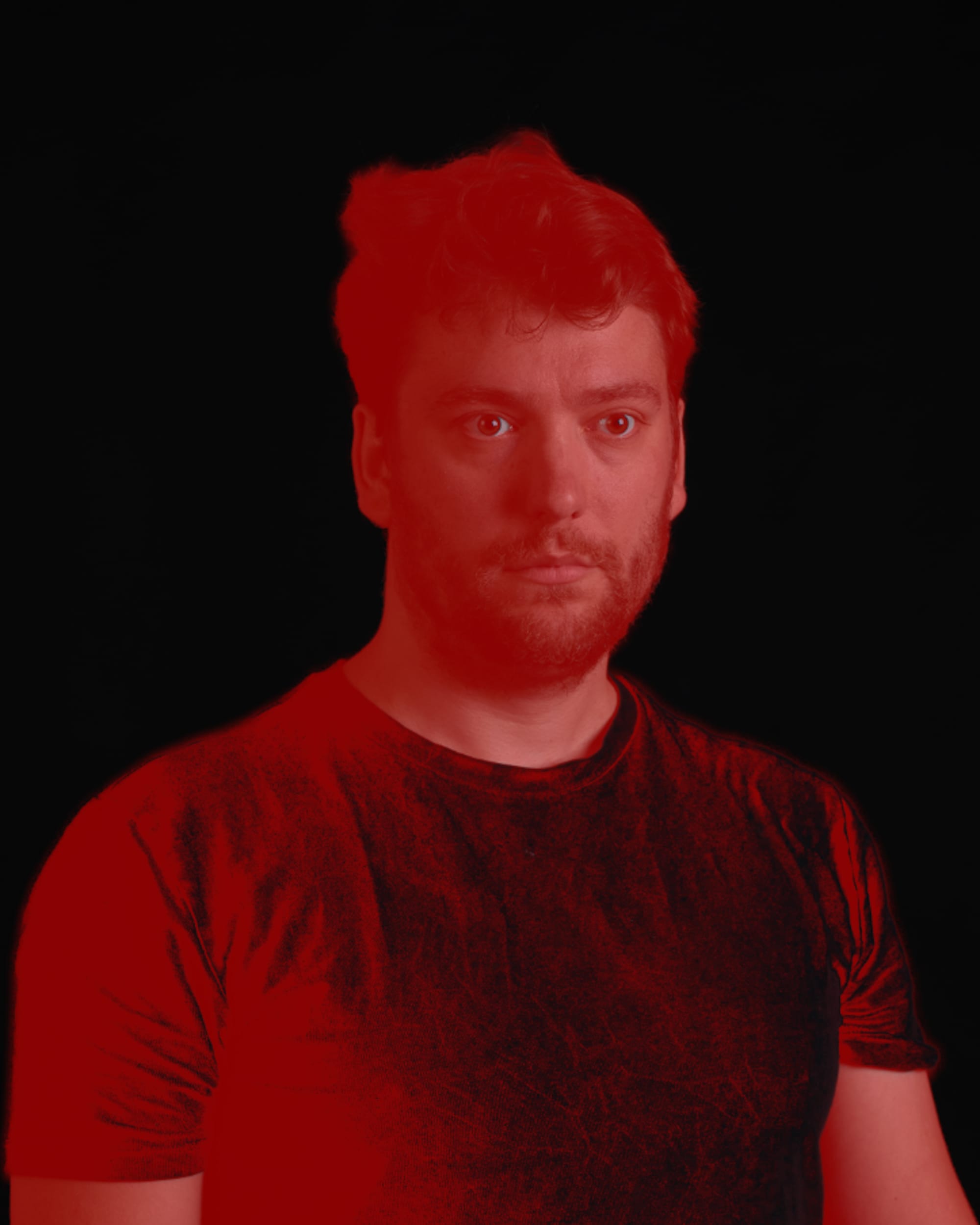 A monochrome studio self-portrait; my torso and head have been made red by a mask in Adobe Lightroom.
