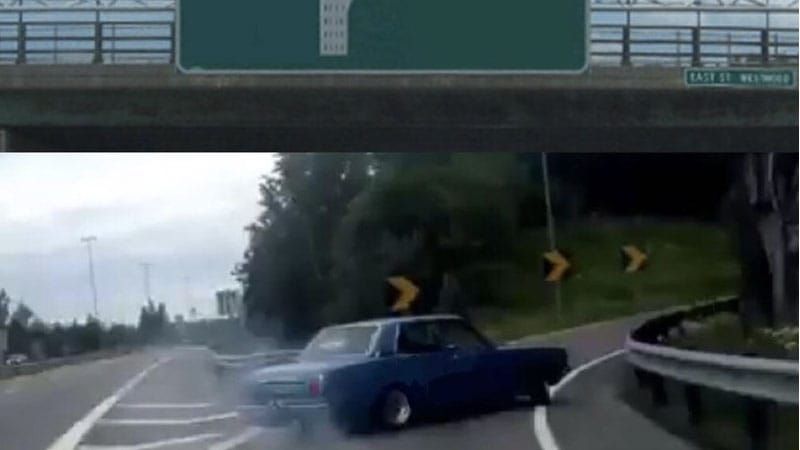 A car veering off a motorway towards an exit, seemingly at the last minute