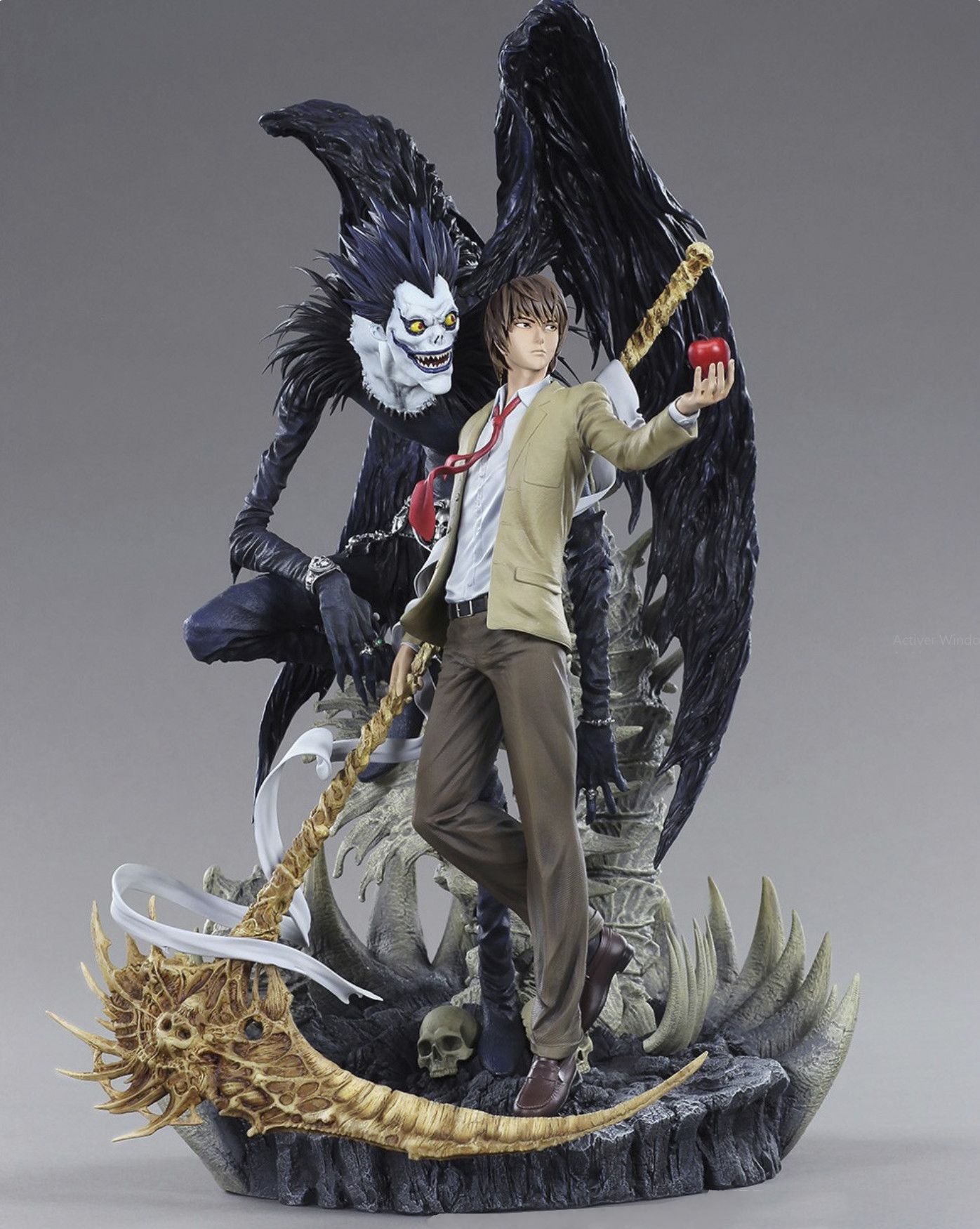 A statue of a person holding an apple and a sword
Description automatically generated