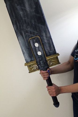 A person holding a large black and gold sword

Description automatically generated