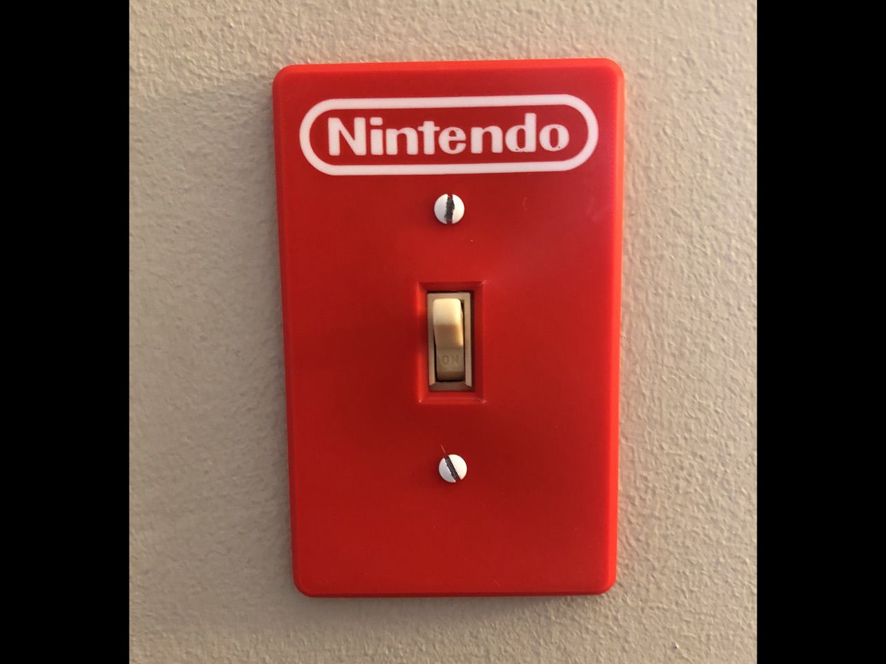 A red switch on a wall

Description automatically generated