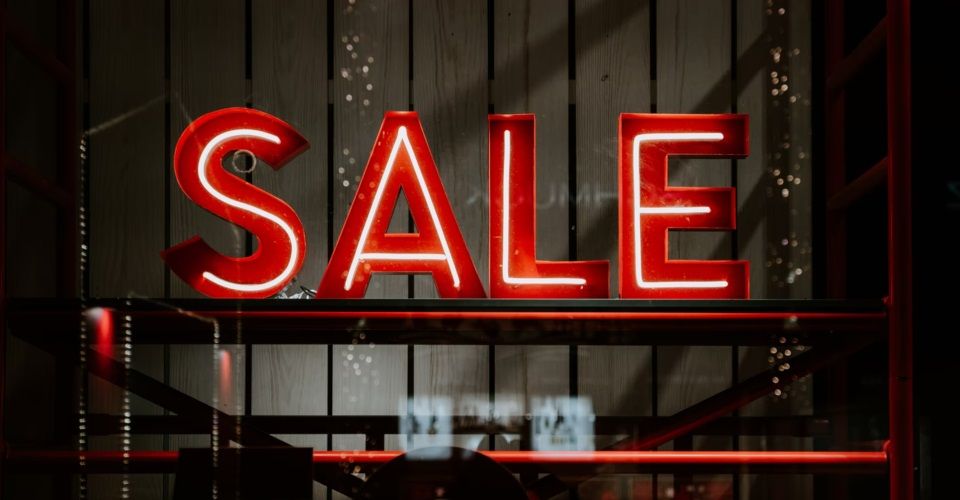 A red neon sign on a shelf

Description automatically generated