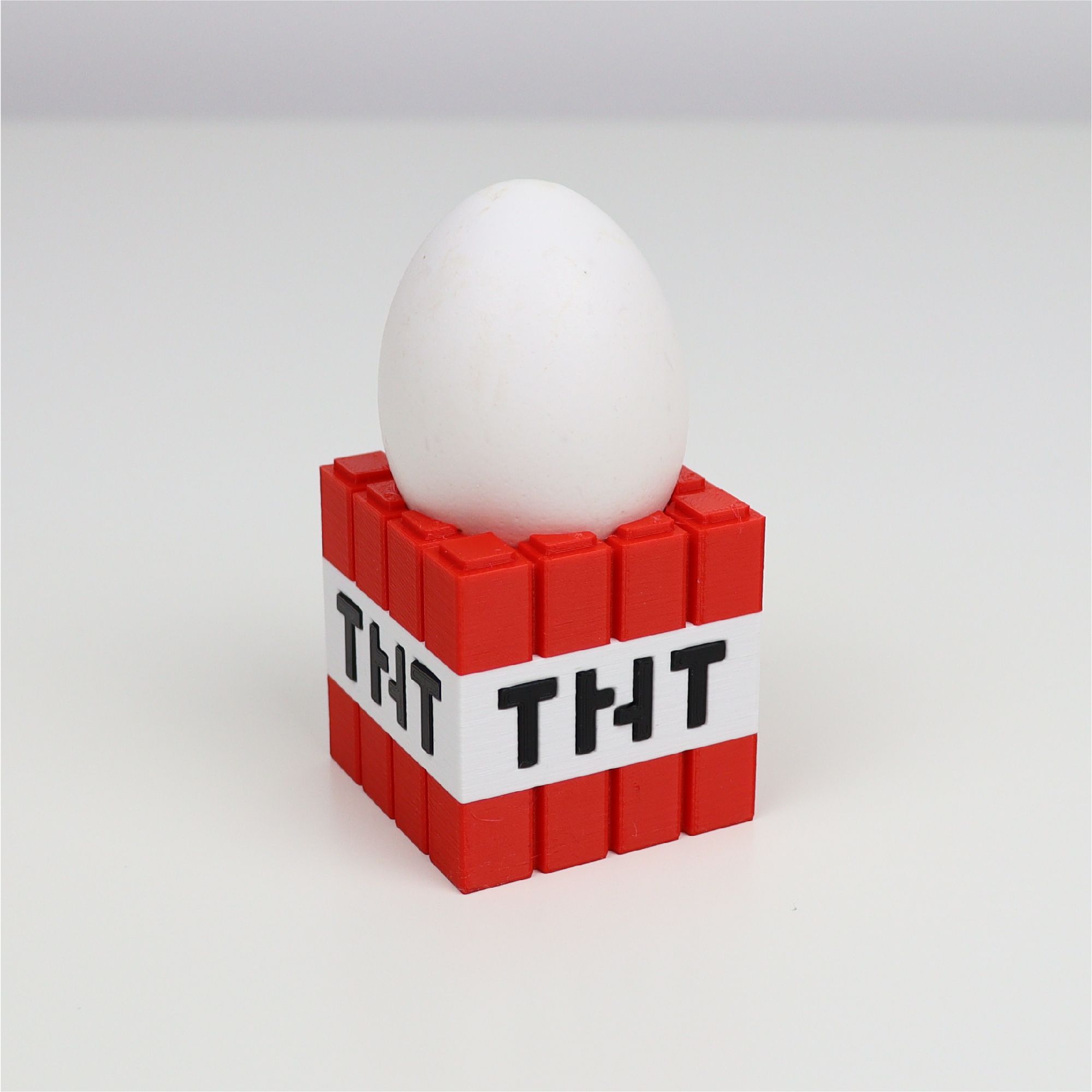 A white egg in a red and white block

Description automatically generated