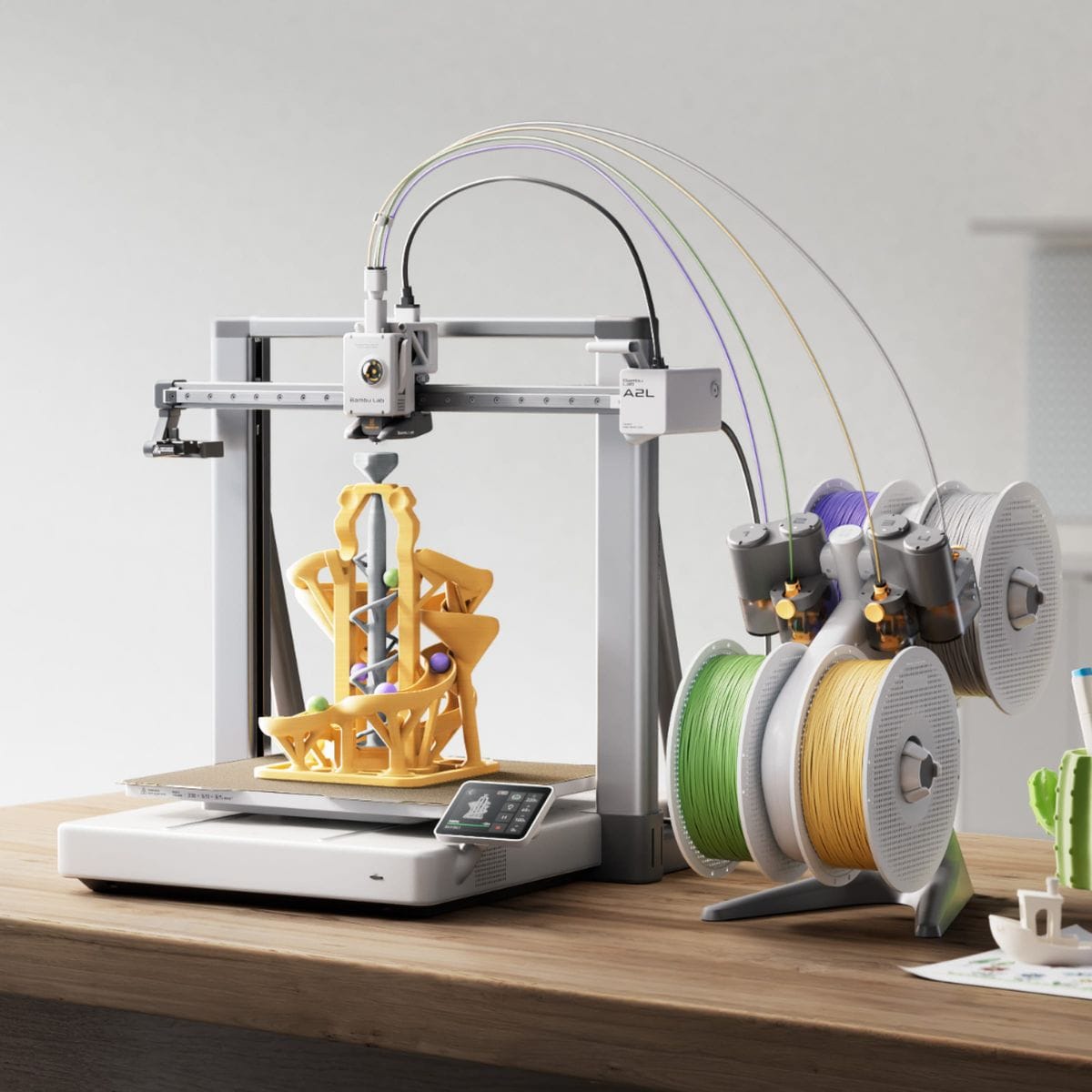 Bambu Lab A2L printing a large model on a desk with AMS lite and filament spools