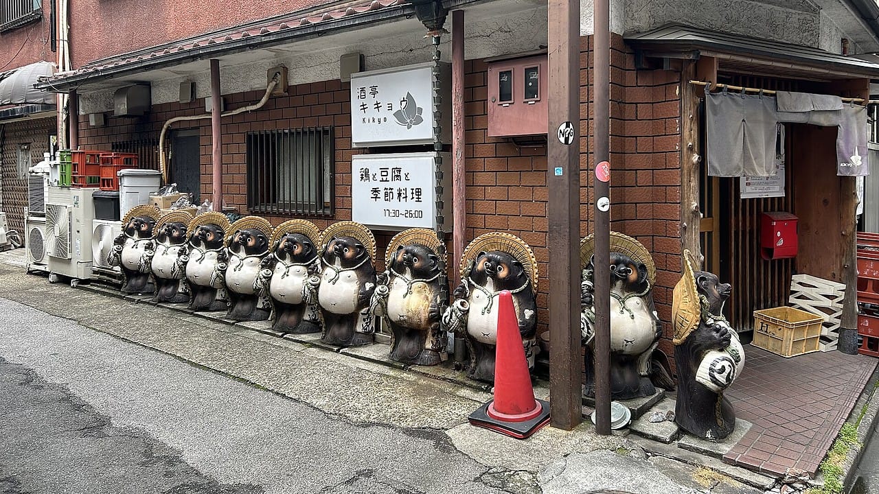 A row of Shigaraki ware tanuki statues lined up outside an izakaya in Tokyo