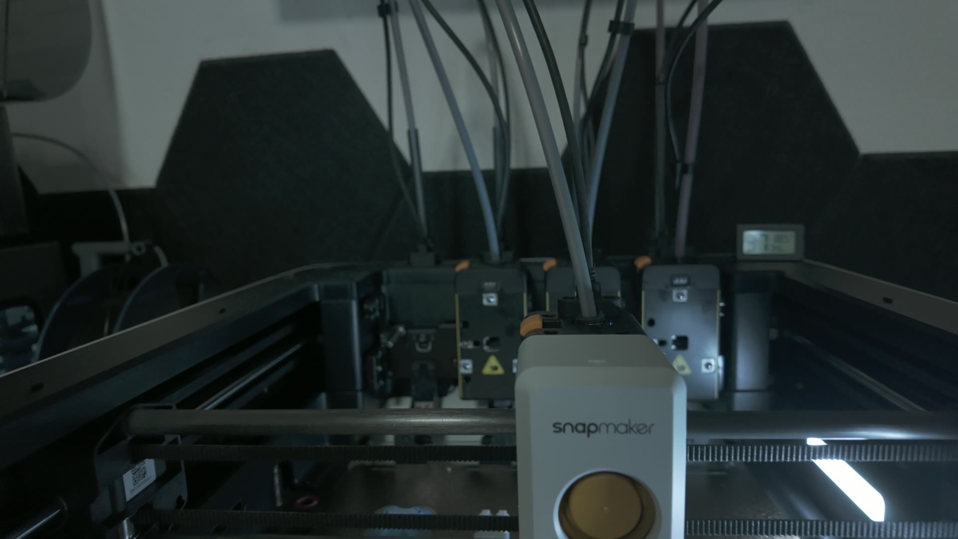 The Snapmaker U1's four independent toolheads parked at the back of the frame, each fed by its own filament