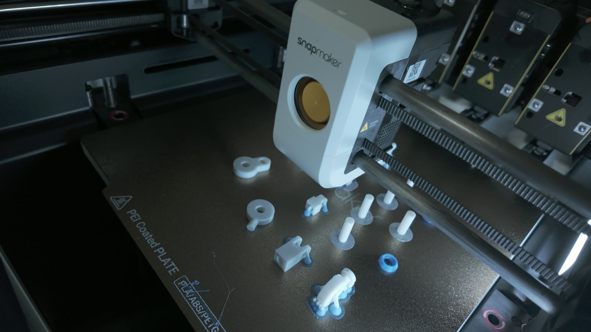 Snapmaker U1 toolhead over freshly printed mech knight parts on the PEI build plate